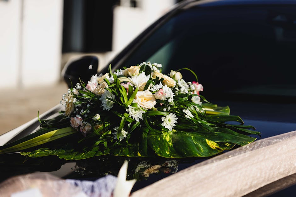 A close-up view of a floral bouquet featuring light pink roses, white lisianthus, and purple freesia, arranged in a rounded, lush style with green foliage accents. The flowers appear fresh, with delic